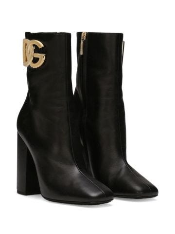 Black boots with gold logo plaque