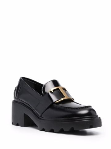 Black loafers with gold logo plaque