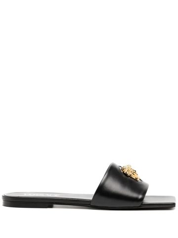 Black leather slip-on low sandals with gold logo